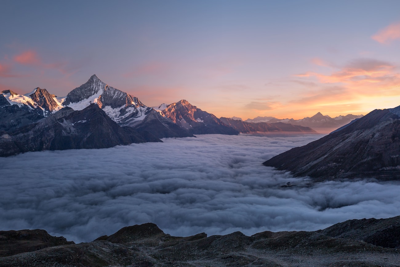 Mountain peaks rising above a sea of clouds at dawn